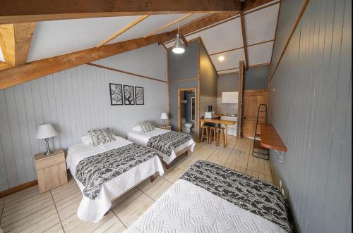 a room with two beds and a table and a kitchen at Apart Hotel y Cabañas Valle Exploradores in Puerto Tranquilo