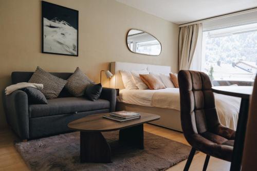 a living room with a bed and a couch and a table at Apartment in Engelberg in Engelberg