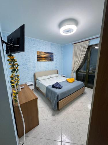 a bedroom with a bed and a flat screen tv at Appartamento CasaSoleMare Fondachello in Fondachello