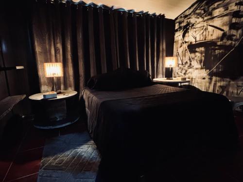 a bedroom with a bed and two tables with lamps at Casa Atelier AXM in Salento