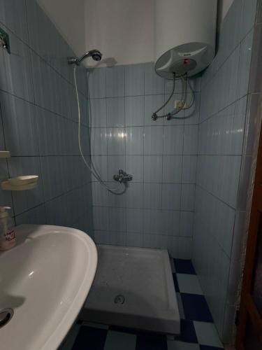 a small bathroom with a sink and a shower at Green House in Pogradec