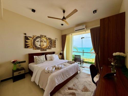 a bedroom with a bed with a view of the ocean at Hotel Beach Castle in Arugam Bay