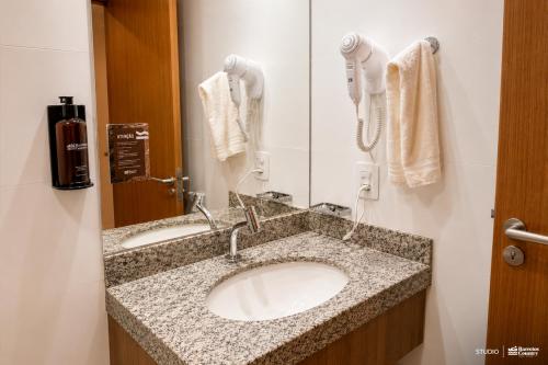 a bathroom with two sinks and a phone on the wall at Barretos Country Park & Resort in Barretos