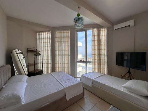 a bedroom with two beds and a flat screen tv at Vila Era in Shëngjin