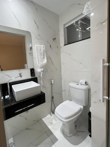 ein weißes Badezimmer mit Toilette und Waschbecken in der Unterkunft Viso Hotel in Tianguá