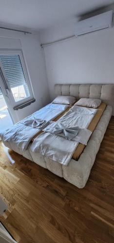 a large bed in a room with a window at mala Atina in Petrovaradin