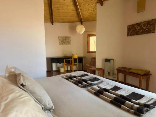 a bedroom with a white bed with a stone object on it at Hotel Tulor in San Pedro de Atacama