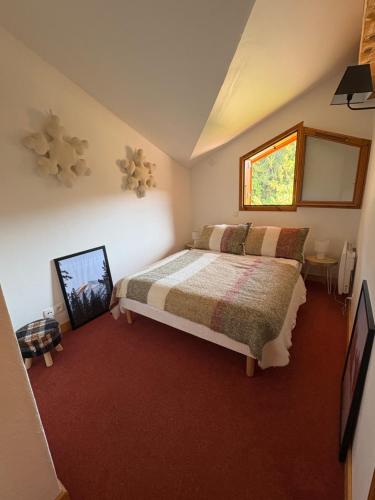 a bedroom with a bed and a window at Maison MAEL in Notre-Dame-de-Bellecombe