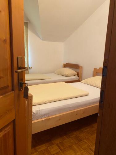 two beds in a room with a door open at Estrada Cazin in Ostrožac