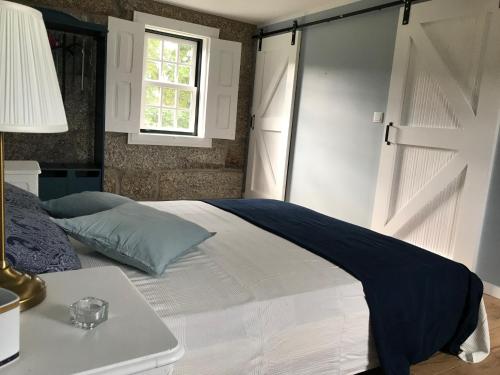 a bedroom with a bed with a sliding door at Casa da Ponte in Baião