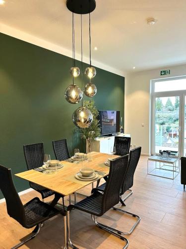 a dining room with a wooden table and chairs at STAY - City M17 in Tettnang