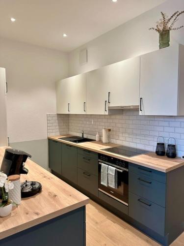a kitchen with white cabinets and a wooden counter top at STAY - City M17 in Tettnang