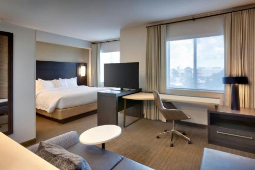 a hotel room with a bed and a desk with a computer at Residence Inn by Marriott Lenexa City Center in Lenexa