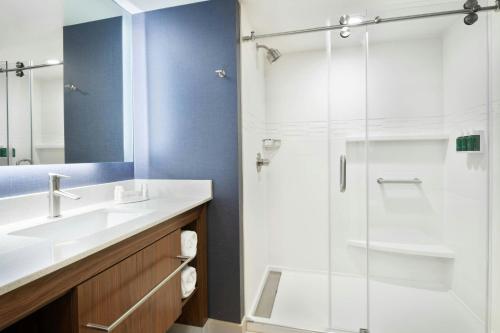 a bathroom with a glass shower and a sink at Residence Inn by Marriott Lenexa City Center in Lenexa