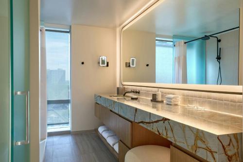 a bathroom with a large mirror and a sink at JW Marriott Atlanta Downtown in Atlanta