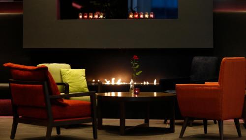 a room with a table and chairs and a fire place at Hotel Reykjavík Grand in Reykjavík
