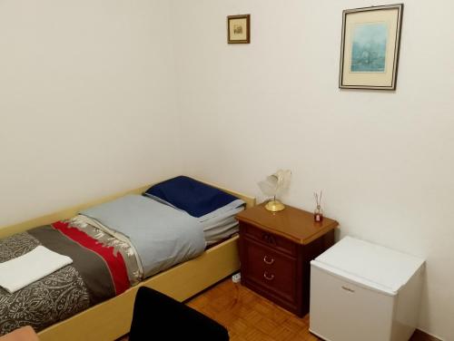 a small bedroom with a bed and a night stand at Camera singola in appartamento in Pordenone