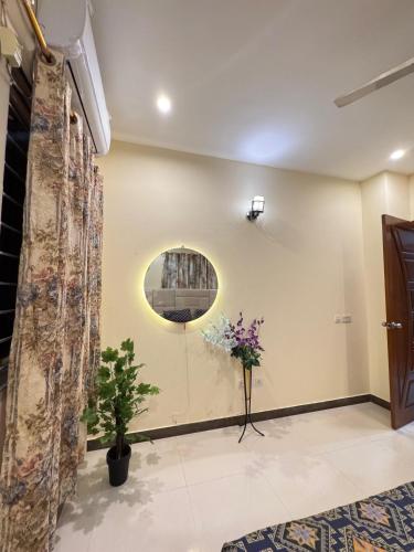 a room with a round mirror and flowers on the wall at Dream home 2 & 4 bedroom Family house in Karachi