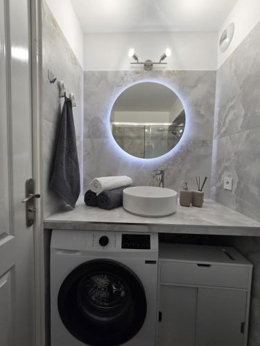 a bathroom with a washing machine and a mirror at Cozy Seaside Studio with Private Parking in Nice