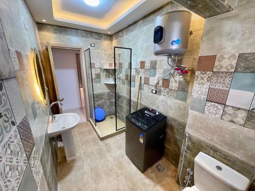 a bathroom with a shower and a toilet and a sink at Sea & Pool View Deluxe Chalet - Prime Spot in Badr Resort in El Alamein