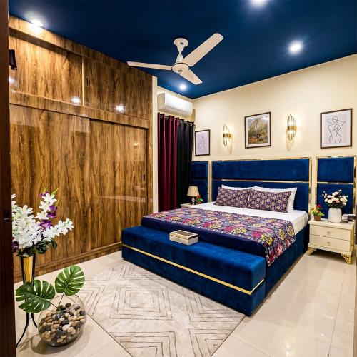 a bedroom with a blue bed and a wooden wall at Dream home 2 & 4 bedroom Family house in Karachi