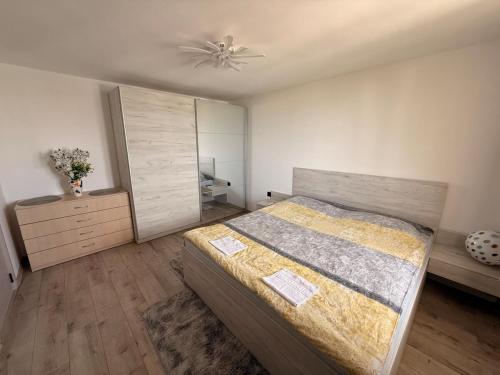 a bedroom with a bed and a dresser at Sunrise Panorama Apartment in Bŭnzareto