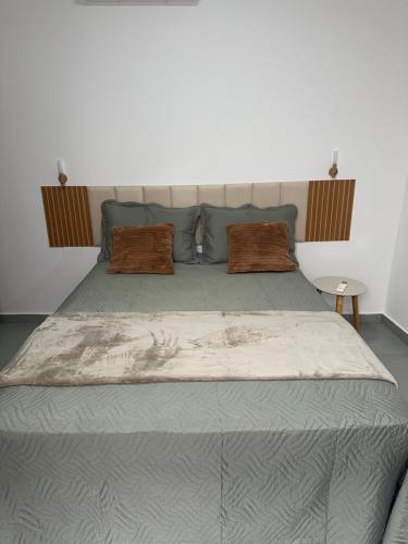 a bedroom with a large bed with two pillows at Apartamento aconchegante em Irecê in Irecê