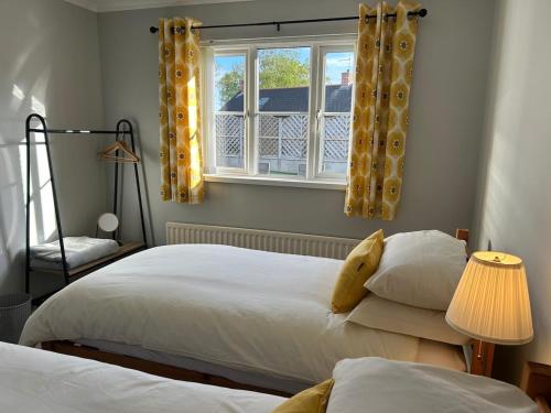 a bedroom with two beds and a window at Rose Cottage in Portadown