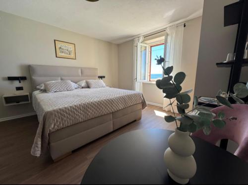 ein Schlafzimmer mit einem Bett und einer Vase auf einem Tisch in der Unterkunft Accommodation Stella Mare in Bol