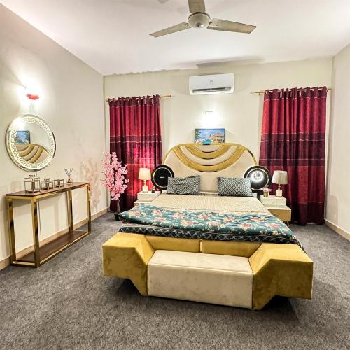 a bedroom with a large bed and red curtains at Aroma Palace Dha in Karachi