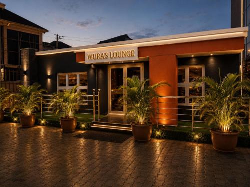 a restaurant with potted plants in front of a building at The Tusk Hotel in Kuje