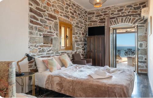 ein Schlafzimmer mit einem großen Bett und einer Steinwand in der Unterkunft Castle Rizaraki in Kokkala