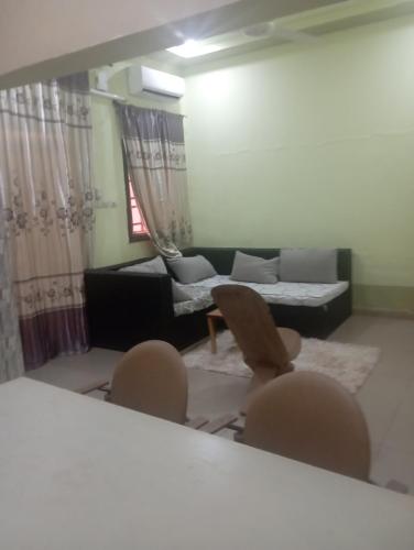 a living room with a couch and a table and chairs at Unique in Ouagadougou