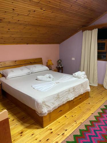 a bedroom with a large bed with two towels on it at Blero Rooms Rent in Pogradec
