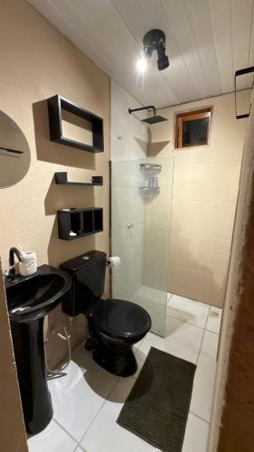 a bathroom with a toilet and a glass shower at Guajiru Beach House KiteSurf in Trairi