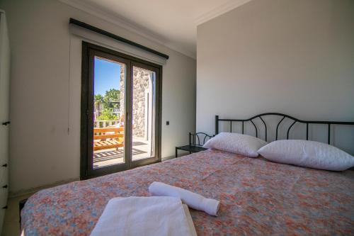 a bedroom with a bed and a large window at Villa Stone Bodrum - Private Pool & Garden in Bodrum City