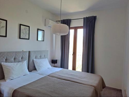 a bedroom with a large bed and a window at Zen Olive Retreat in Petrovac na Moru