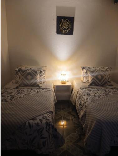 two beds in a room with a clock on the wall at Cachipay panche in Cachipay