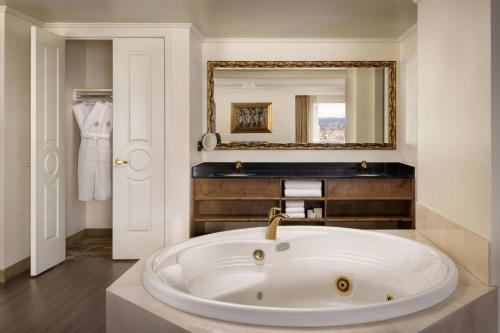 a large bath tub in a bathroom with a mirror at The Davenport Tower, Autograph Collection in Spokane