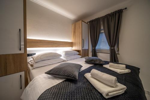 a bedroom with two beds with towels on them at Apartments Bajcic in Rab