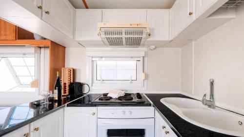 a white kitchen with a sink and a counter top at 1A Casa Azul in Pataias
