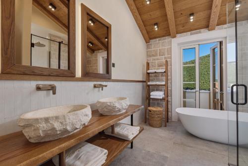 a bathroom with two sinks and a bath tub at MiraMare in Luštica