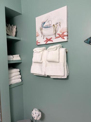 a bathroom with white towels hanging on a wall at Waves, Sun & Relaxation Retreat in Clearwater Beach