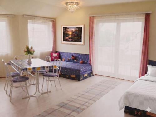 a bedroom with a bed and a table and chairs at Lipták Vendégház in Balatonfüred