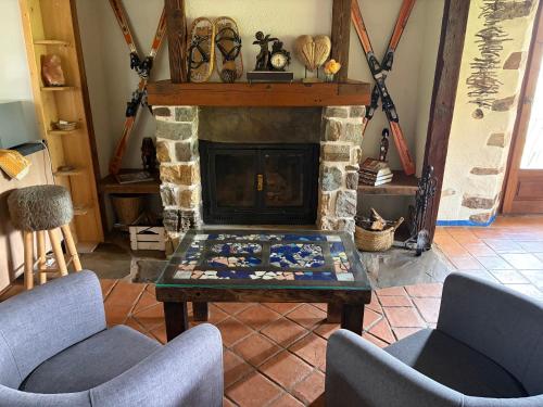 a living room with two chairs and a fireplace at Las Casas del Nogal - Guesthouse en Sierra Nevada in Güéjar-Sierra