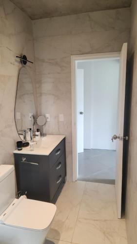 a bathroom with a toilet and a sink and a mirror at lazy beach in Punta del Este