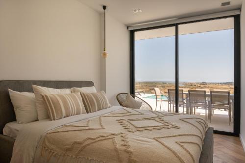 a bedroom with a bed and a view of a patio at Villa Aurora Luxury Villa with Infinity Pool in Portimão