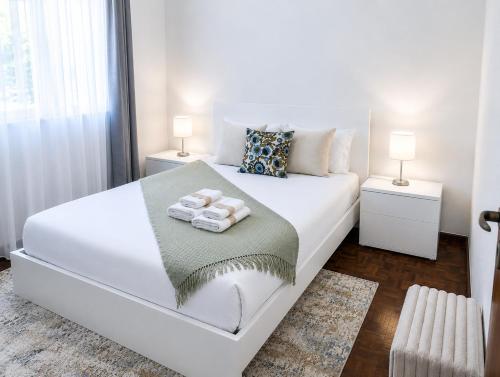 a bedroom with a white bed with towels on it at Villa Herédia - 5 min form the beach in Ribeira Brava