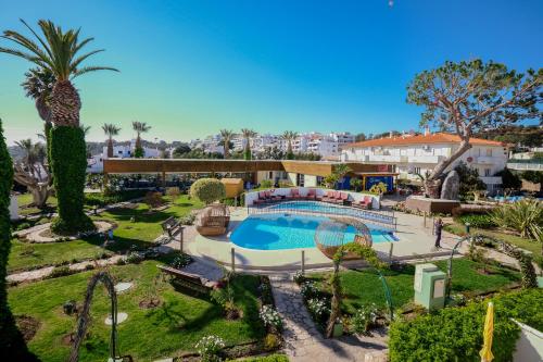 a resort with a swimming pool and palm trees at Muthu Clube Praia da Oura in Albufeira