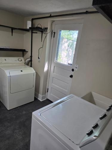 a laundry room with a washer and a white door at Beach Vacation Home in Rochester